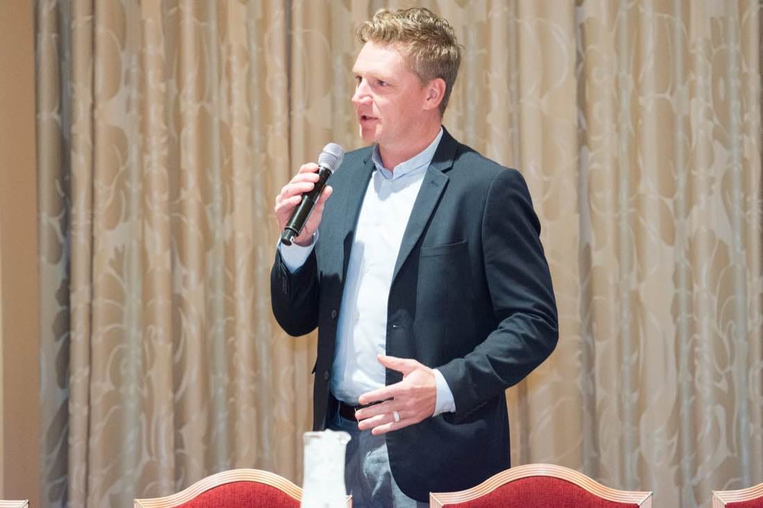 Chris Travis of Koenig & Bauer presenting with a handheld microphone at a Print UV session