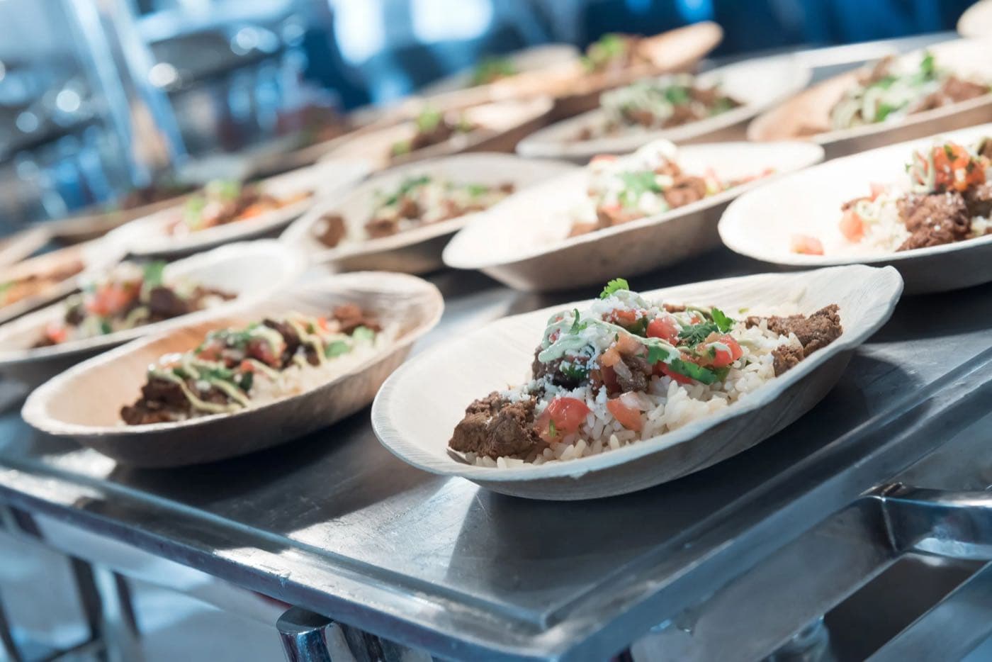 Close-up of freshly plated dishes lined up under warming lights